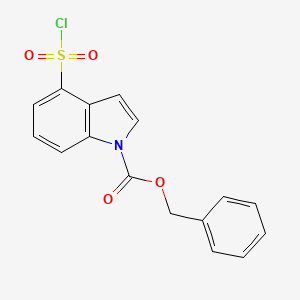 molecular formula C16H12ClNO4S B13157284 Benzyl 4-(chlorosulfonyl)-1H-indole-1-carboxylate 