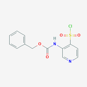 molecular formula C13H11ClN2O4S B13204635 Benzyl N-[4-(chlorosulfonyl)pyridin-3-yl]carbamate 