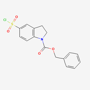 molecular formula C16H14ClNO4S B13233003 Benzyl 5-(chlorosulfonyl)-2,3-dihydro-1H-indole-1-carboxylate 