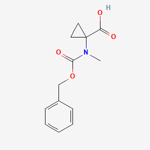 molecular formula C13H15NO4 B13256037 1-{[(Benzyloxy)carbonyl](methyl)amino}cyclopropane-1-carboxylic acid 