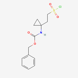molecular formula C13H16ClNO4S B13306562 Benzyl N-{1-[2-(chlorosulfonyl)ethyl]cyclopropyl}carbamate 