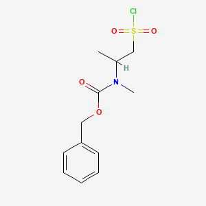 molecular formula C12H16ClNO4S B13315741 Benzyl N-[1-(chlorosulfonyl)propan-2-yl]-N-methylcarbamate 