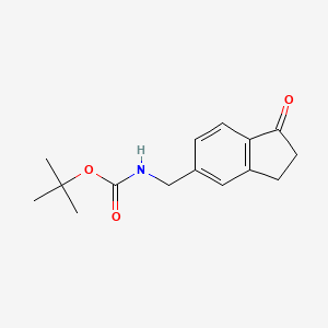 molecular formula C15H19NO3 B13407066 tert-butyl N-[(1-oxo-2,3-dihydro-1H-inden-5-yl)methyl]carbamate 