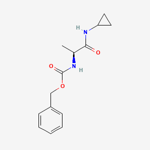 molecular formula C14H18N2O3 B1377921 Benzyl N-[(1S)-1-(cyclopropylcarbamoyl)ethyl]carbamate CAS No. 1314806-92-2