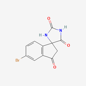 molecular formula C11H7BrN2O3 B1381844 5'-Bromospiro[imidazolidine-4,1'-[1H]indene]-2,3',5(2'H)-trione CAS No. 1889290-24-7