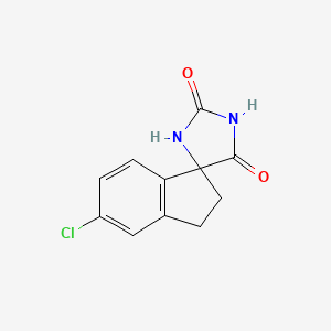 molecular formula C11H9ClN2O2 B1455649 5'-Chloro-2',3'-dihydrospiro[imidazolidine-4,1'-indene]-2,5-dione CAS No. 351528-73-9