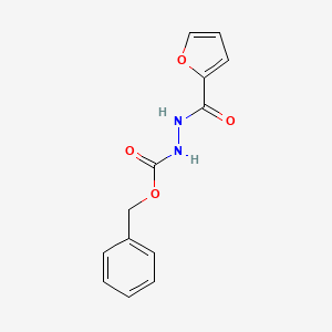 molecular formula C13H12N2O4 B1475661 Benzyl 2-(furan-2-carbonyl)hydrazinecarboxylate CAS No. 1501977-18-9