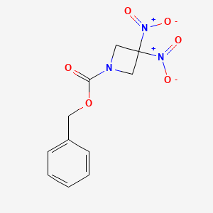 molecular formula C11H11N3O6 B1611481 1-Azetidinecarboxylic acid, 3,3-dinitro-, phenylmethyl ester CAS No. 147636-85-9