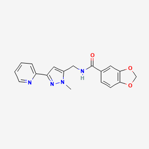 molecular formula C18H16N4O3 B2677653 N-{[1-methyl-3-(pyridin-2-yl)-1H-pyrazol-5-yl]methyl}-2H-1,3-benzodioxole-5-carboxamide CAS No. 2319722-71-7
