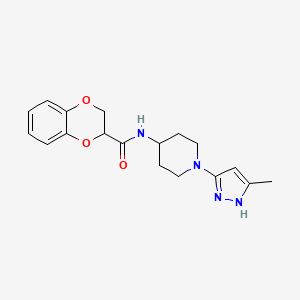 molecular formula C18H22N4O3 B2745455 N-[1-(5-methyl-1H-pyrazol-3-yl)piperidin-4-yl]-2,3-dihydro-1,4-benzodioxine-2-carboxamide CAS No. 2034204-94-7
