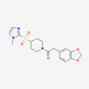 molecular formula C18H21N3O5S B2806590 2-(2H-1,3-benzodioxol-5-yl)-1-{4-[(1-methyl-1H-imidazol-2-yl)sulfonyl]piperidin-1-yl}ethan-1-one CAS No. 2320465-04-9