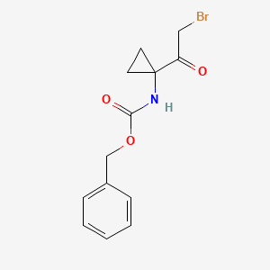 molecular formula C13H14BrNO3 B2937499 benzyl N-[1-(2-bromoacetyl)cyclopropyl]carbamate CAS No. 1566334-59-5