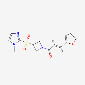 molecular formula C14H15N3O4S B2947460 (E)-3-(furan-2-yl)-1-(3-((1-methyl-1H-imidazol-2-yl)sulfonyl)azetidin-1-yl)prop-2-en-1-one CAS No. 2321336-05-2