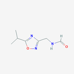 molecular formula C7H11N3O2 B054317 N-[(5-propan-2-yl-1,2,4-oxadiazol-3-yl)methyl]formamide CAS No. 122384-65-0