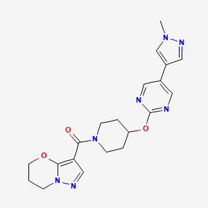 B6462905 5-(1-methyl-1H-pyrazol-4-yl)-2-[(1-{5H,6H,7H-pyrazolo[3,2-b][1,3]oxazine-3-carbonyl}piperidin-4-yl)oxy]pyrimidine CAS No. 2549054-17-1