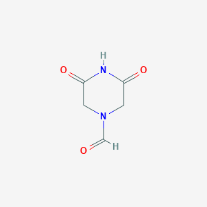 molecular formula C5H6N2O3 B065985 3,5-Dioxopiperazine-1-carbaldehyde CAS No. 165824-59-9