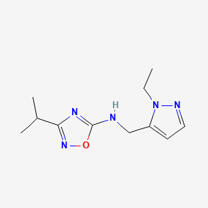 molecular formula C11H17N5O B7120842 N-[(2-ethylpyrazol-3-yl)methyl]-3-propan-2-yl-1,2,4-oxadiazol-5-amine 