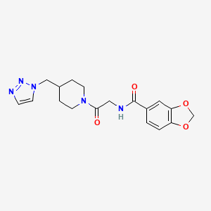molecular formula C18H21N5O4 B7151788 N-[2-oxo-2-[4-(triazol-1-ylmethyl)piperidin-1-yl]ethyl]-1,3-benzodioxole-5-carboxamide 