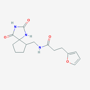 molecular formula C15H19N3O4 B7189528 N-[(2,4-dioxo-1,3-diazaspiro[4.4]nonan-9-yl)methyl]-3-(furan-2-yl)propanamide 