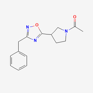 molecular formula C15H17N3O2 B7609875 1-[3-(3-Benzyl-1,2,4-oxadiazol-5-yl)pyrrolidin-1-yl]ethanone 