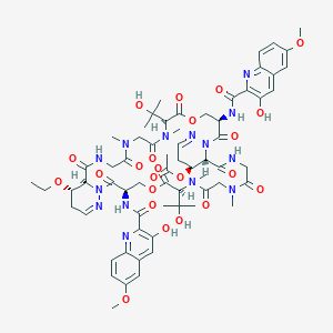molecular formula C64H80N14O23 B8101660 [(3R,7S,16S,17S,23R,27S,36S,37S)-37-ethoxy-3,23-bis[(3-hydroxy-6-methoxyquinoline-2-carbonyl)amino]-7,27-bis(2-hydroxypropan-2-yl)-8,11,28,31-tetramethyl-2,6,9,12,15,22,26,29,32,35-decaoxo-5,25-dioxa-1,8,11,14,20,21,28,31,34,40-decazatricyclo[34.4.0.016,21]tetraconta-19,39-dien-17-yl] acetate 