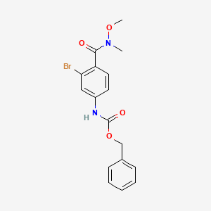 molecular formula C17H17BrN2O4 B8231989 benzyl N-[3-bromo-4-[methoxy(methyl)carbamoyl]phenyl]carbamate 